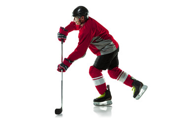 Fototapeta premium Activity. Male hockey player with the stick on ice court and white background. Sportsman wearing equipment and helmet practicing. Concept of sport, healthy lifestyle, motion, movement, action.