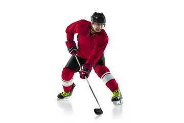 Activity. Male hockey player with the stick on ice court and white background. Sportsman wearing equipment and helmet practicing. Concept of sport, healthy lifestyle, motion, movement, action.