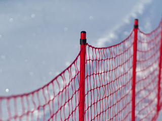 Close-up of a protective red net for skiing. Winter day at the ski resort