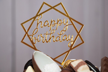 Happy birthday sign on homemade delicious birthday chocolate cake on light table with, close up