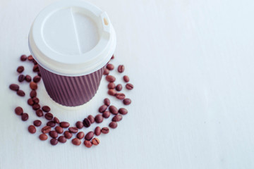 takeaway coffee in a red paper cup and with coffee grains