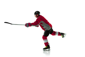 Leader. Male hockey player with the stick on ice court and white background. Sportsman wearing...