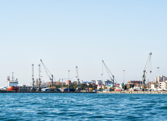 Panoramic view of sea port with loading cranes and ships