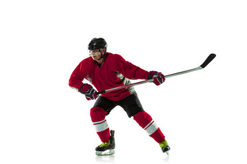 Leader. Male hockey player with the stick on ice court and white background. Sportsman wearing equipment and helmet practicing. Concept of sport, healthy lifestyle, motion, movement, action.