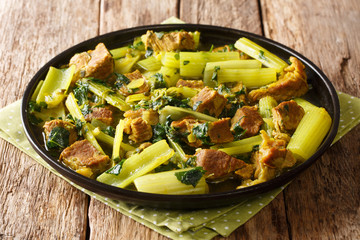 portion of stewed celery with beef, onions, mint and parsley closeup in a plate. horizontal