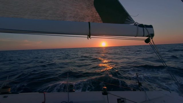 Mast of sail boat or yacht move gently in sunset in open ocean. Epic cinematic sunrise during yacht trip of lifetime at summer vacation. Inspirational wanderlust video for new experiences and memories