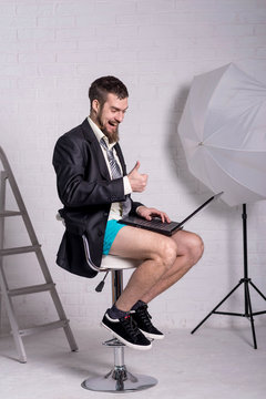 Man in a jacket and shorts is sitting with a laptop, the concept of remote work.