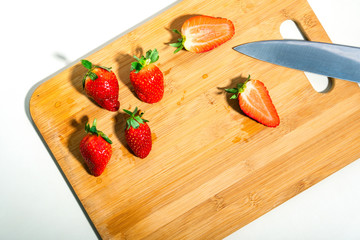 red strawberries on a wooden cutting board
