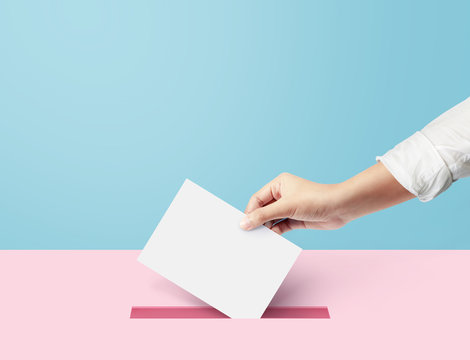 Hand holding ballot paper for election vote concept at blue backdrop. minimal composition concept.