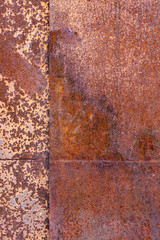 two sheets of rusty metal welded together lie on each other.