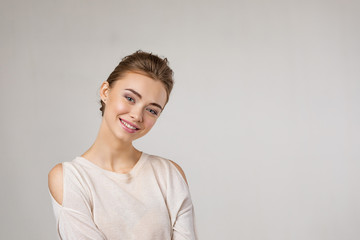 Fototapeta premium smiling happy young beautiful woman looking at camera on gray background.