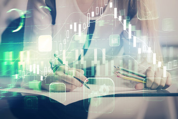 Double exposure of hands making notes with forex chart huds. Stock market concept.