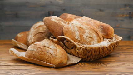 Assortment of baked bread on wooden table background. Bread background, top view of white, black and rye loaves. Healthy food. 