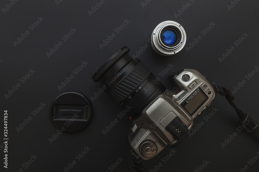 Sticker Photographer workplace with dslr camera system and lens on dark black table background. Hobby travel photography concept. Flat lay top view copy space.