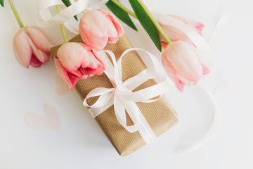 Happy womens day. Pink tulips flat lay with ribbon and gift box on white background. Stylish soft image of spring flowers. Greeting card mockup. Happy Mothers day. Hello spring