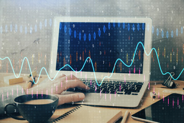 Forex graph with businessman working on computer in office on background. Concept of hardworking....