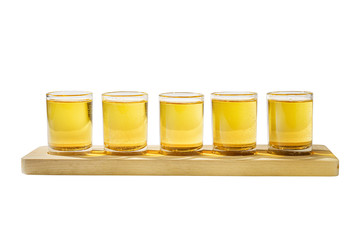 Yellow, same color opaque cocktails, a set of shots in one row, five servings on a wooden stand, substrate, side view Isolated white background. Drink for the menu restaurant, bar, cafe