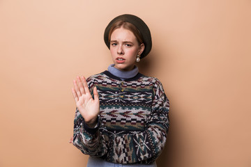Photo of caucasian displeased woman in earrings making stop gesture