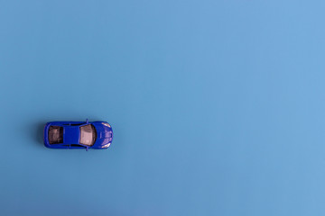 Little blue car. Children’s toy on a blue background.Flat lay. Top view. Copy space for text