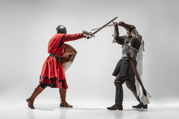 Brave armored knights with professional weapon fighting isolated on white studio background....