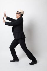 Full body of an adult asian man push something.