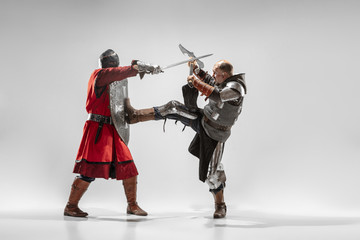 Brave armored knights with professional weapon fighting isolated on white studio background....