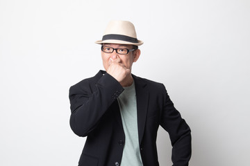 adult asian man  holding his nose because of a bad smell.