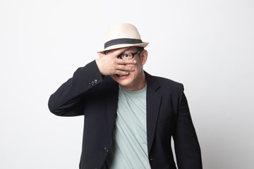 adult asian man peeking through fingers.