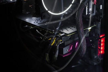 Obraz premium Close-up video card with backlight inside a computer on a black background. The concept of computer games, cyber sports and computer repair. Banner format, wallpapers.