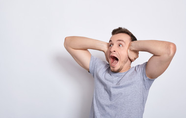 Shocked screaming young guy in T-shirt.