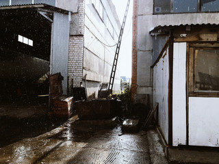 Industrial area during the rain. Passage between the buildings.