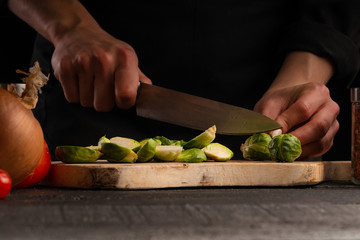 Cooking salad with vegetables, slicing fresh vegetables on a black background. Healthy and proper nutrition. Vegetation