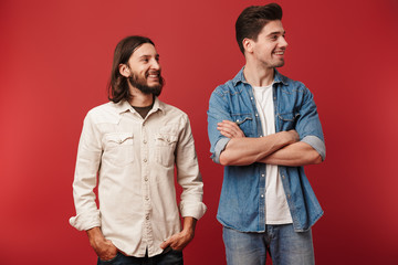 Two cheerful young men wearing casual clothes standing