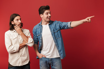 Two cheerful young men wearing casual clothes standing