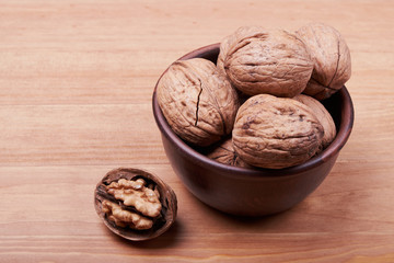 Walnut kernels and whole walnuts on rustic old wooden table