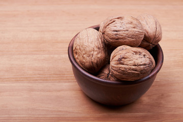 Walnut kernels and whole walnuts on rustic old wooden table