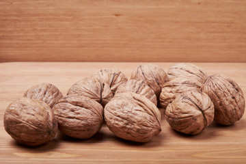 Walnut kernels and whole walnuts on rustic old wooden table