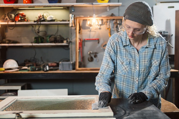 Carpenter working on the old wood in a retro vintage workshop.