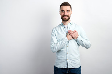 Studio shot portrait of smiling bearded man arms folded at heart level. - Gesturing concept