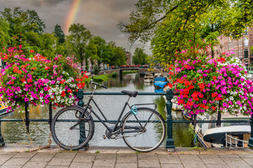 Fototapeta na wymiar Bicycle on a Bridge over a Canal in Amsterdam Netherlands with Rainbow