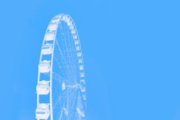 White ferris wheel on a blue color background. Minimal concept. Copy space