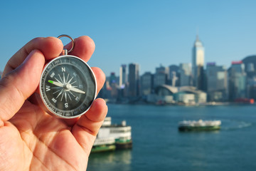 Compass in the hand on the Hong Kong Skyline background