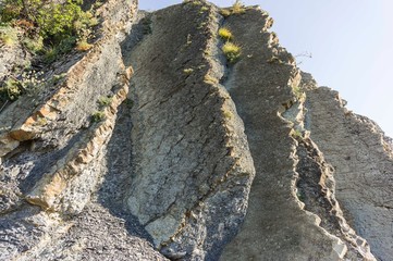 Rocky coast of Black Sea in village of Olginka, Tuapse district. Natural textures protruding on steep slopes of Caucasus Mountains. Close-up. Rock fragments and stones of different sizes as background