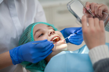 Girl at the dentist's appointment. Inspection of the oral cavity and teeth in a child.
