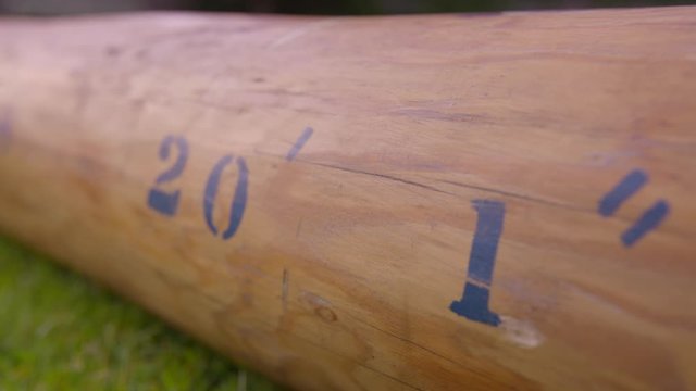 Extreme close-up low angle still shot of a caber with its length of 20' 1 written on its surface, Scottish sportsground, Scotland, UK