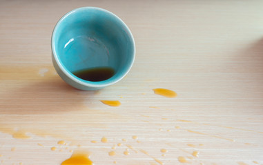 Tea and coffee spilled on the wooden floor.