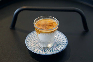 Dirty Coffee - A glass of espresso shot mixed with cold fresh milk on blurred background and copy space, Perfect drink for summer time.