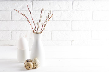 White vase with willow branch , white egg and cups on a white table Copy space Easter concept