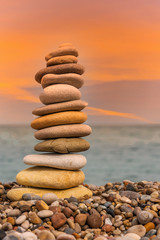 Fototapeta na wymiar Meditative Stone Stack on a Mediterranean Beach in Southern Italy at Sunset