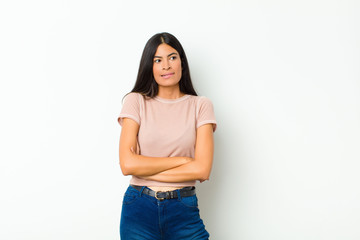 young pretty latin woman doubting or thinking, biting lip and feeling insecure and nervous, looking...